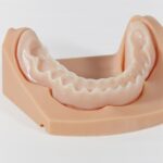 Impresora 3D de resina PioCreat DJ68 9K 13 Prótesis dental en material de resina, mostrando la estructura de una dentadura superior en un modelo de práctica.
